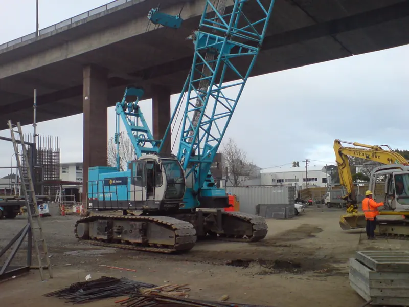 Crawler crane working beside a highway viaduct
